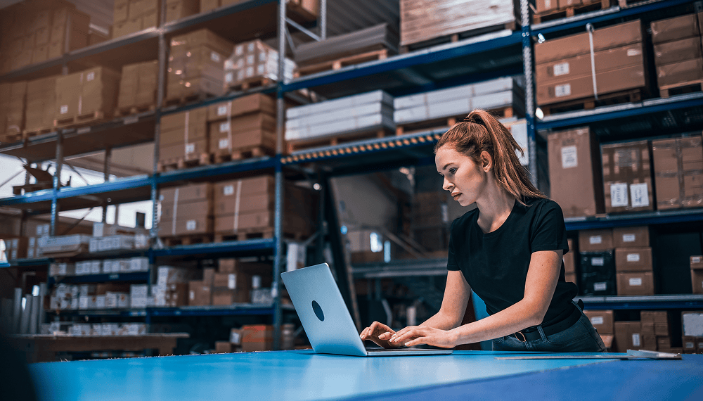 Warehouse manager using control tower software on a laptop 