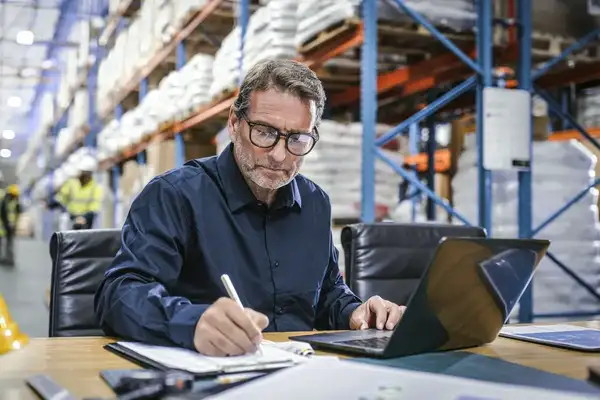 Man working on a laptop in a warehouse
