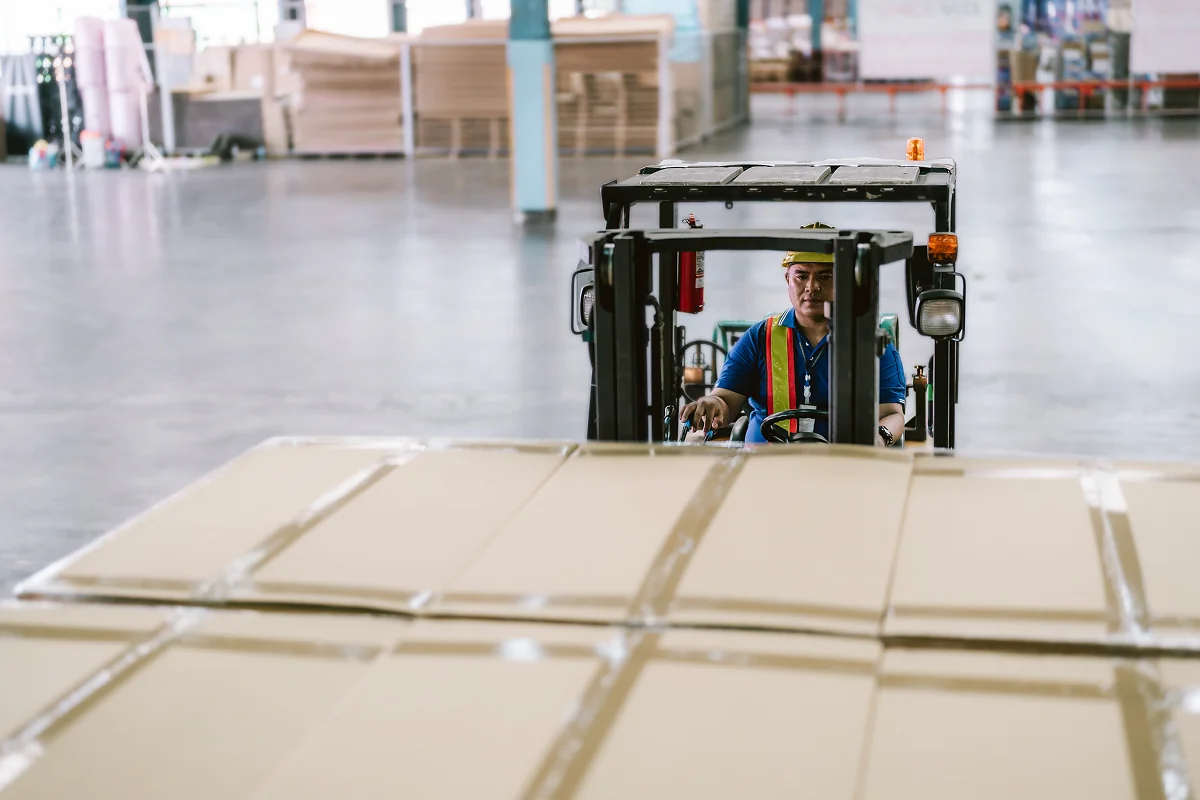 Forklift moving boxes in warehouse