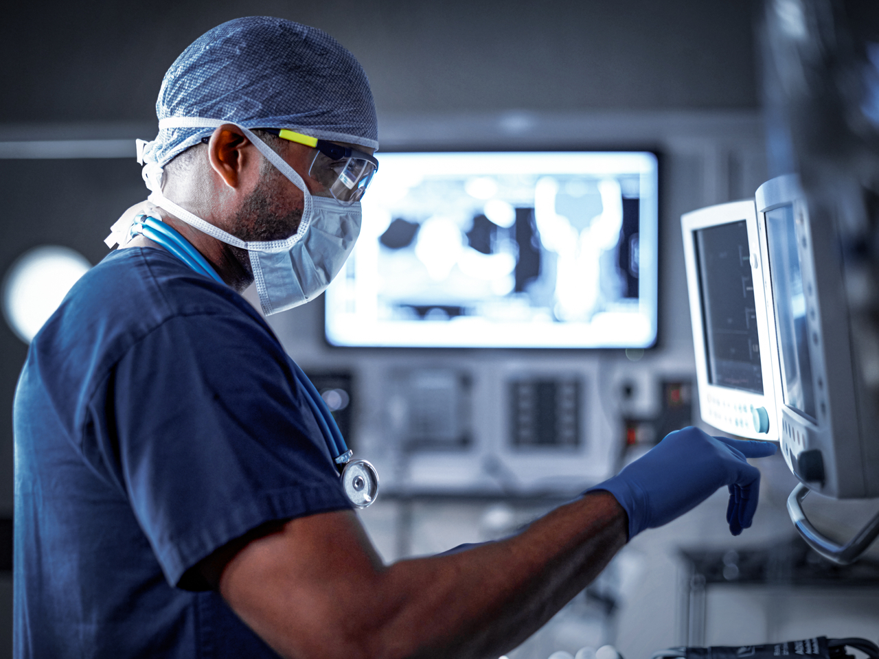 Doctor reviewing patient exam results on multiple screens 