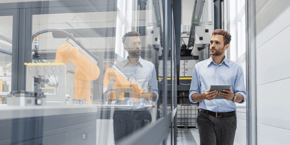 man holding an ipad and assessing factory operations