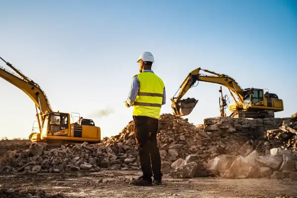 Male DOT project manager overseeing a highway construction project wearing protective gear