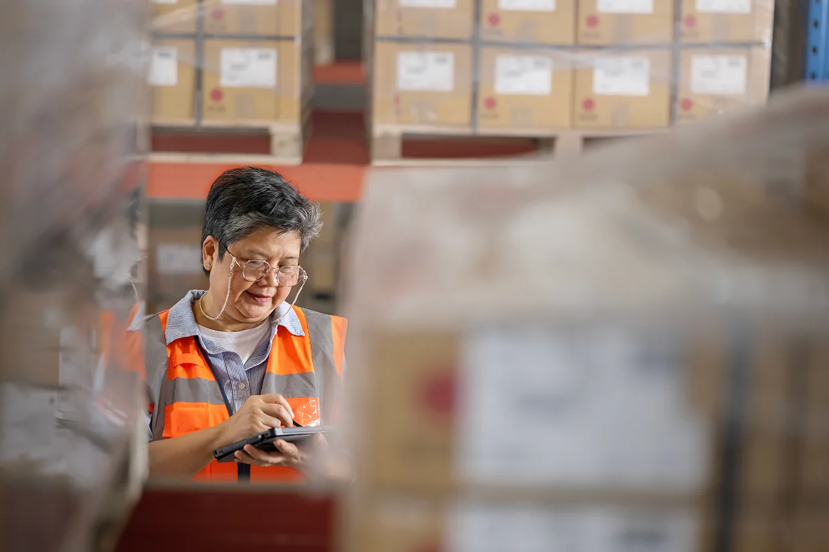 Warehouse manager using supplier management software on a tablet 