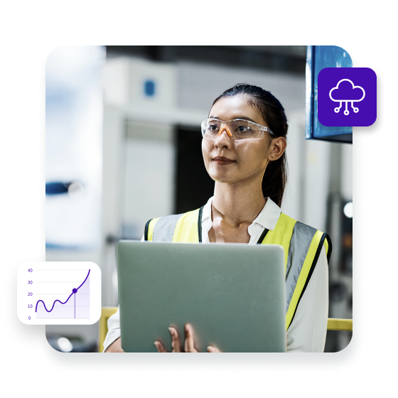 Female Engineer checking an automated mechanical press machine while standing and input data on a laptop