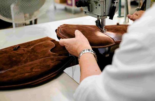 Woman stitching a riding saddle