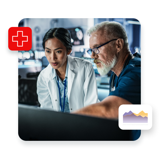 Asian Female Scientist Using Desktop Computer And Talking To Caucasian Male Doctor In Modern Hospital Research Lab