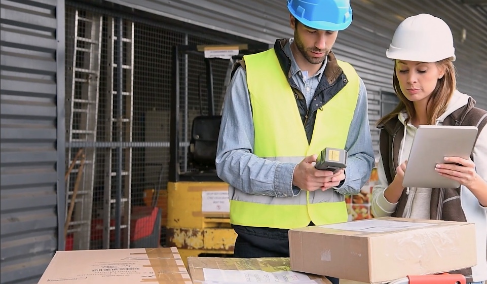 trabalhadores de armazém olhando para um tablet