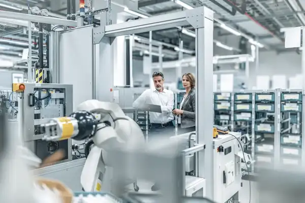 Businesswoman and man with tablet talking in a modern factory
