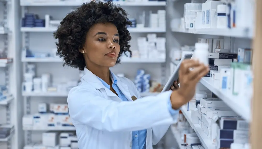 Woman in healthcare at work reviewing files on a work tablet