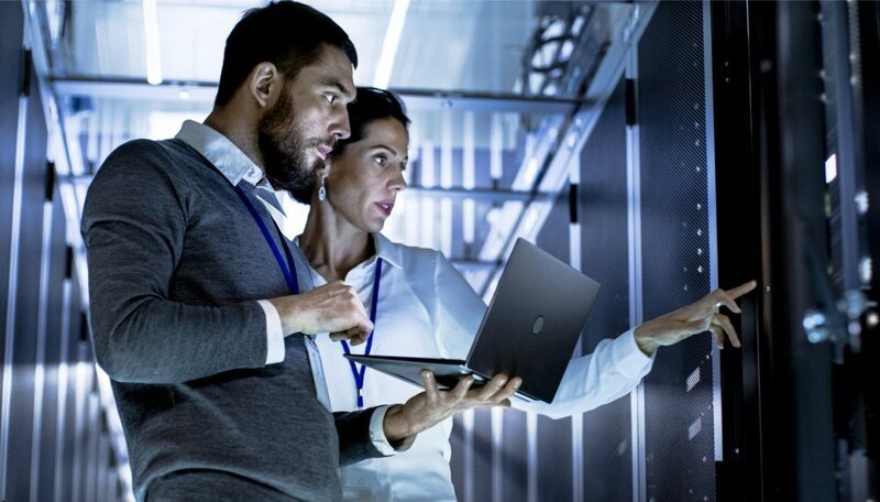 Businesspeople using Infor solutions powered by AWS on a laptop