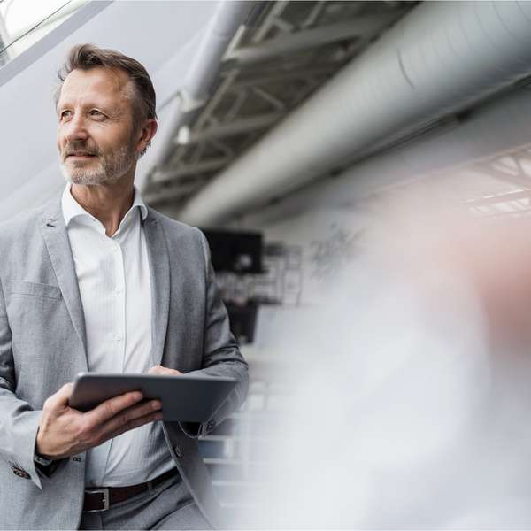 male professional holding digital tablet while standing