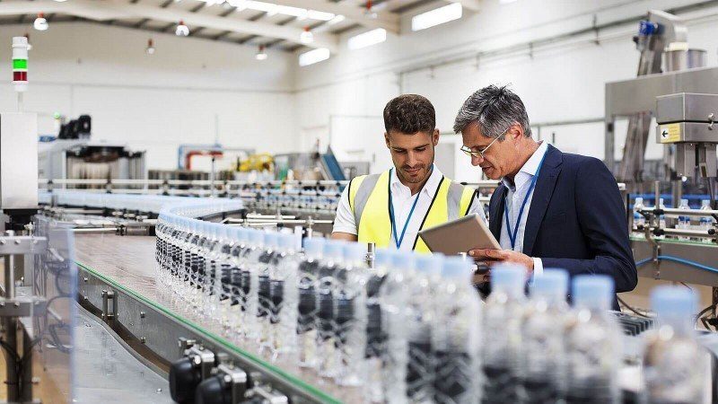 supervisor looking at plastic bottle conveyor