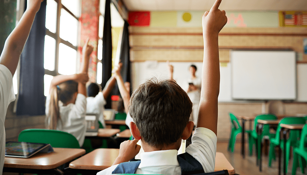 Children raising their hands in a classroom