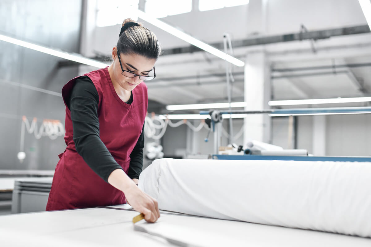 Textile factory worker taking measurements