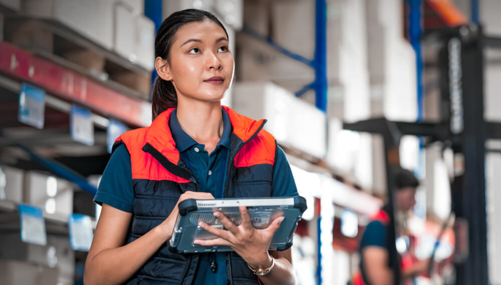 Warehouse supervisor using supply chain traceability software on a tablet