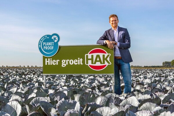 man in vegetable field with company sign