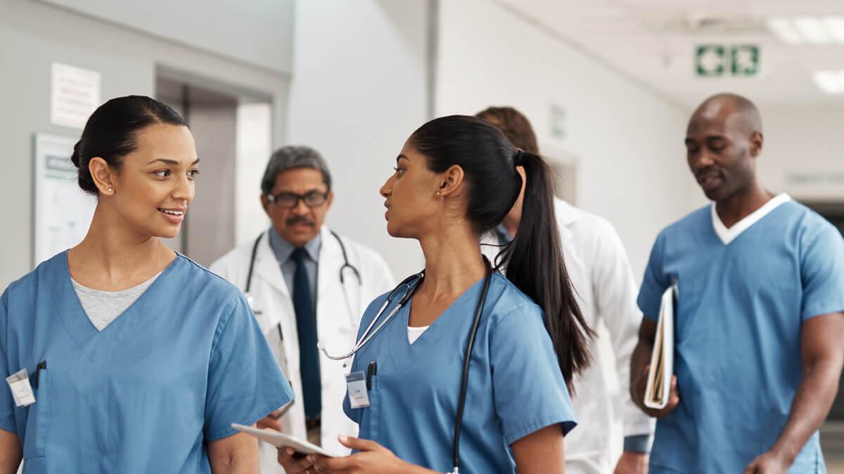 Diverse group of nurses talking and walking together