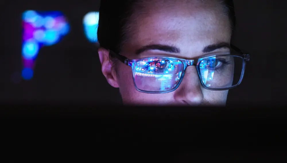 Developer with data reflected in her glasses