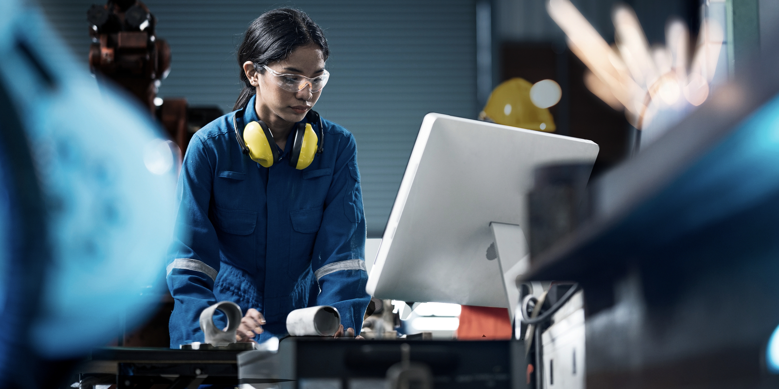 Female Industrial engineer working on desktop computer in robotic welding testing