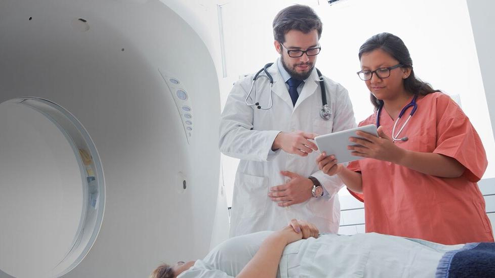 Doctor reviewing patient results on tablet with a nurse