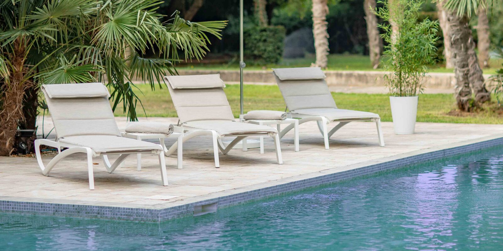 lounge chairs by pool and lawn