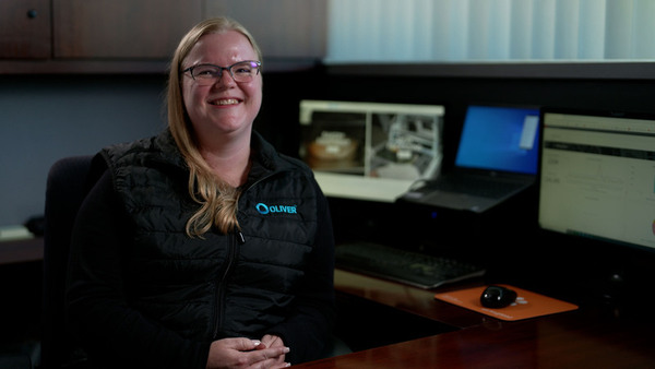 woman in office seated by computer screens on desk