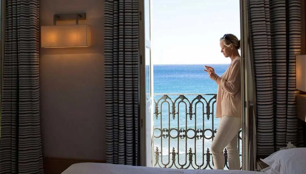 Woman standing on the balcony in suite at the Mandarin Oriental Hotel