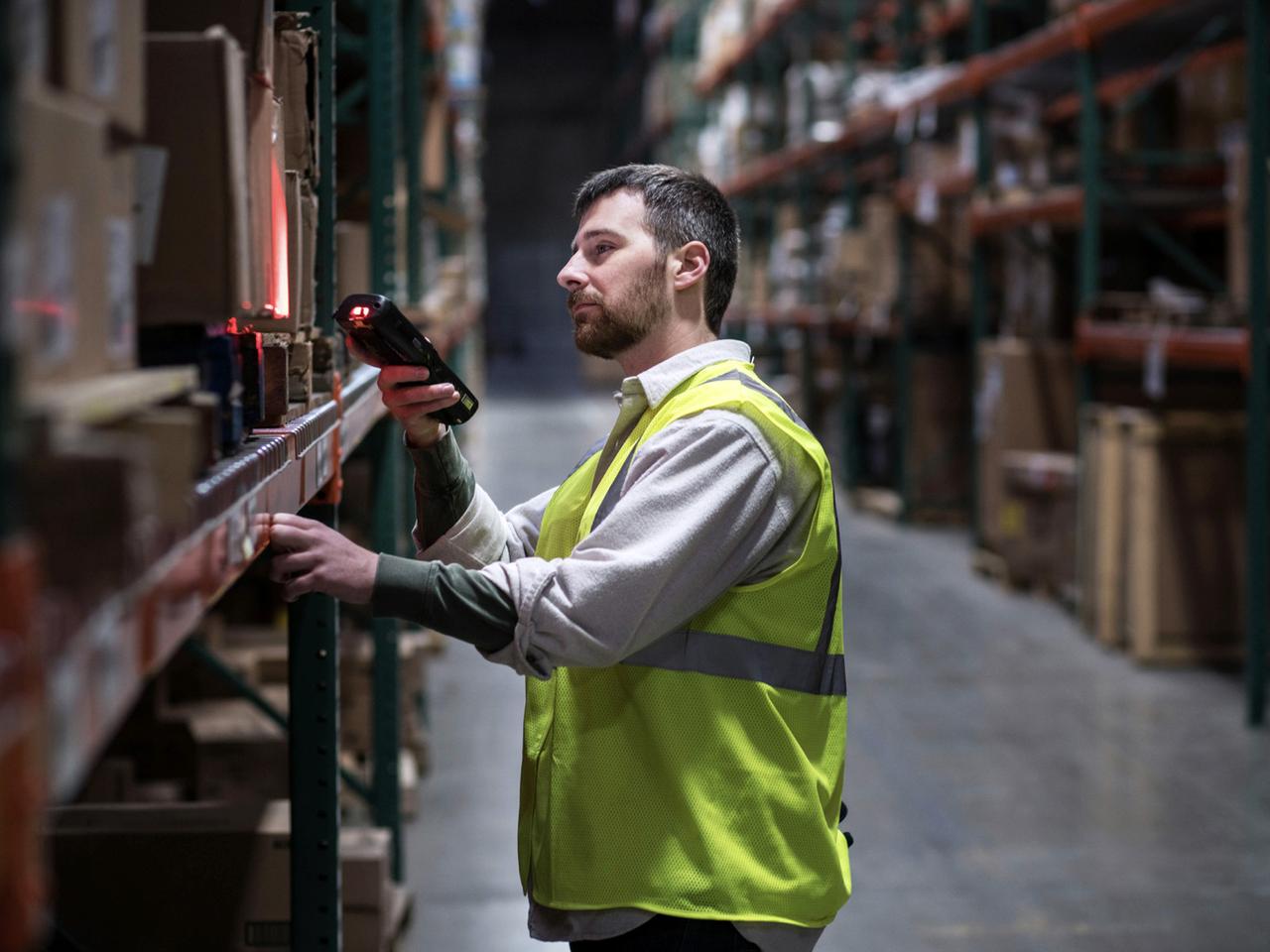 Worker scanning boxes in a distribution warehouse