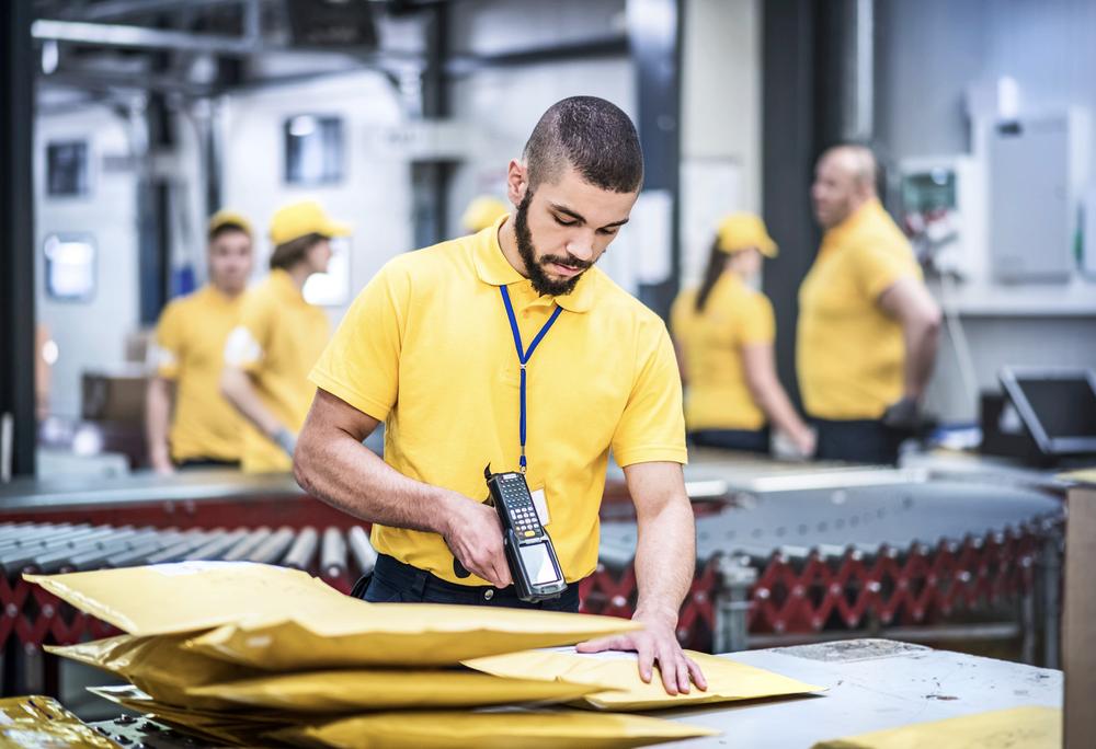 Distribution center worker scanning packages 