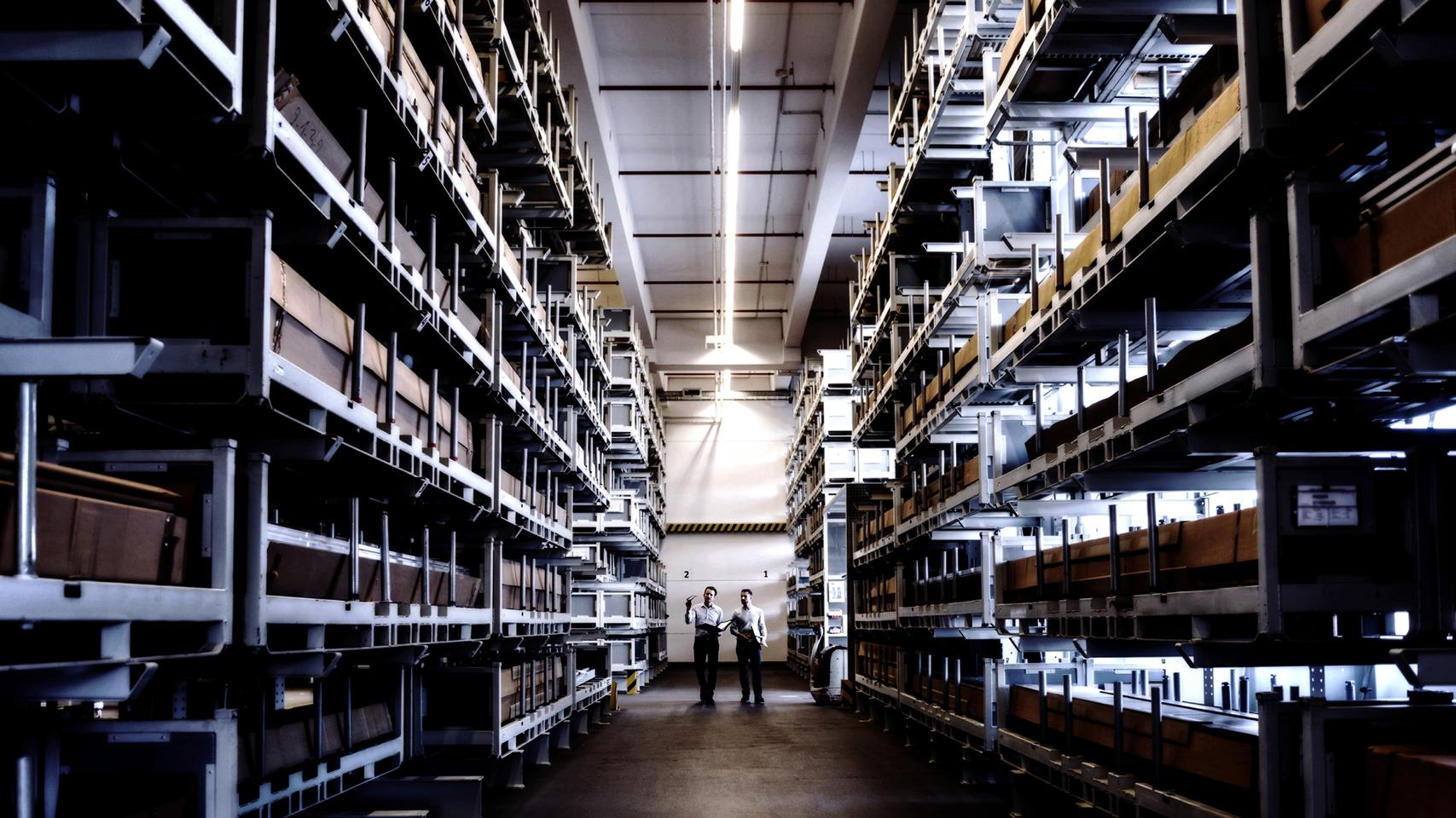 Two men walking in factory warehouse