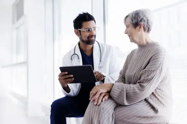 Male doctor sitting with a woman patient explaining a medical diagnosis