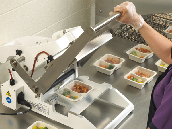 person using food packaging machine