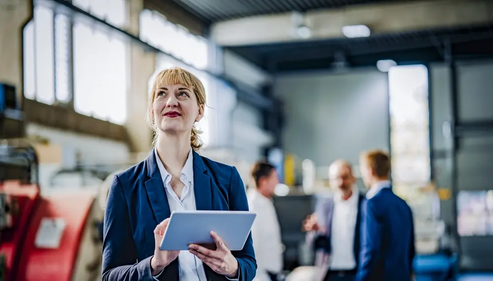 Healthcare supply chain manager with a tablet in a factory