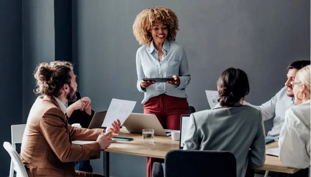 Woman speaking to co-workers in conference room