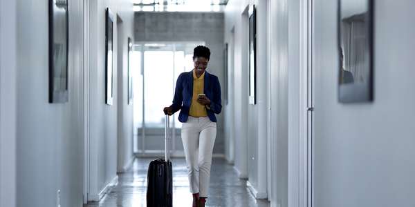 683980938 hsp hotel
  woman walking down hall suitcase mobile phone Getty 1600x800