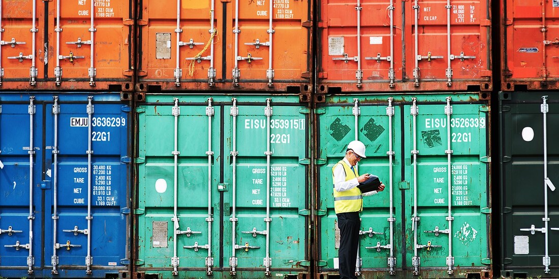 freight worker standing in front of distribution crates