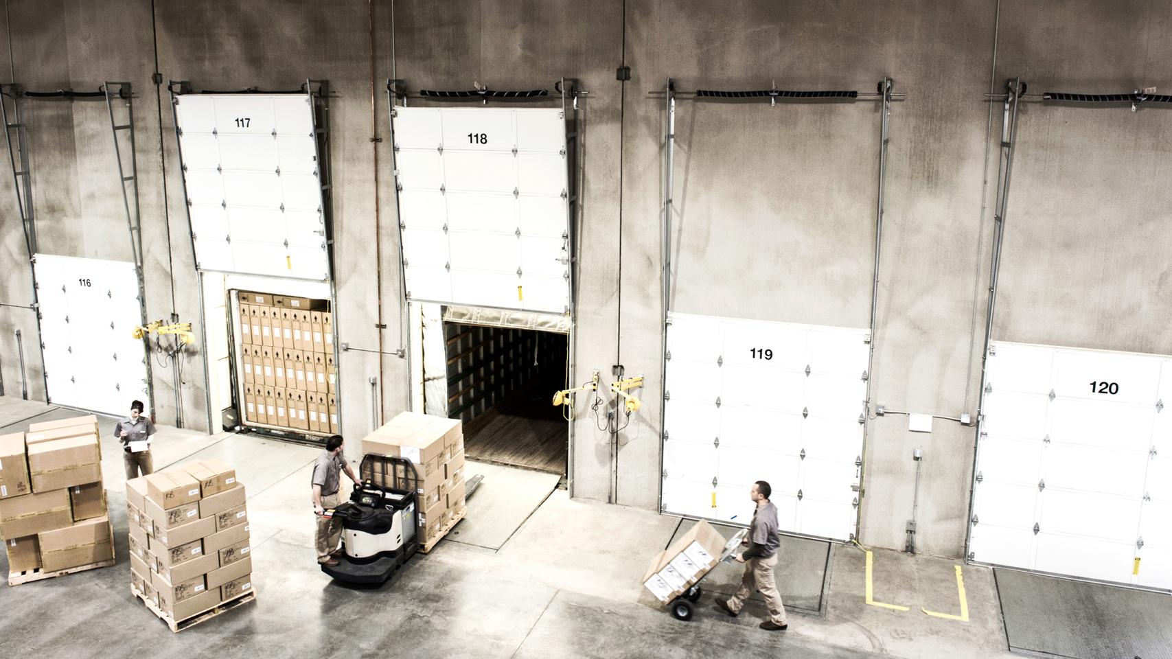 Warehouse workers loading boxes onto trucks 