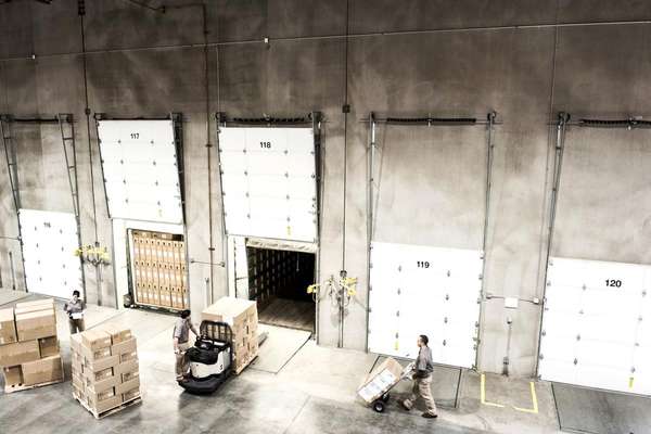 Warehouse workers loading boxes onto trucks 