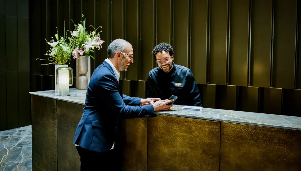 1847793803 Hotel manager helping businessman