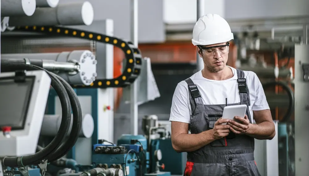 Production supervisor reviewing a scheduling board on a manufacturing floor
