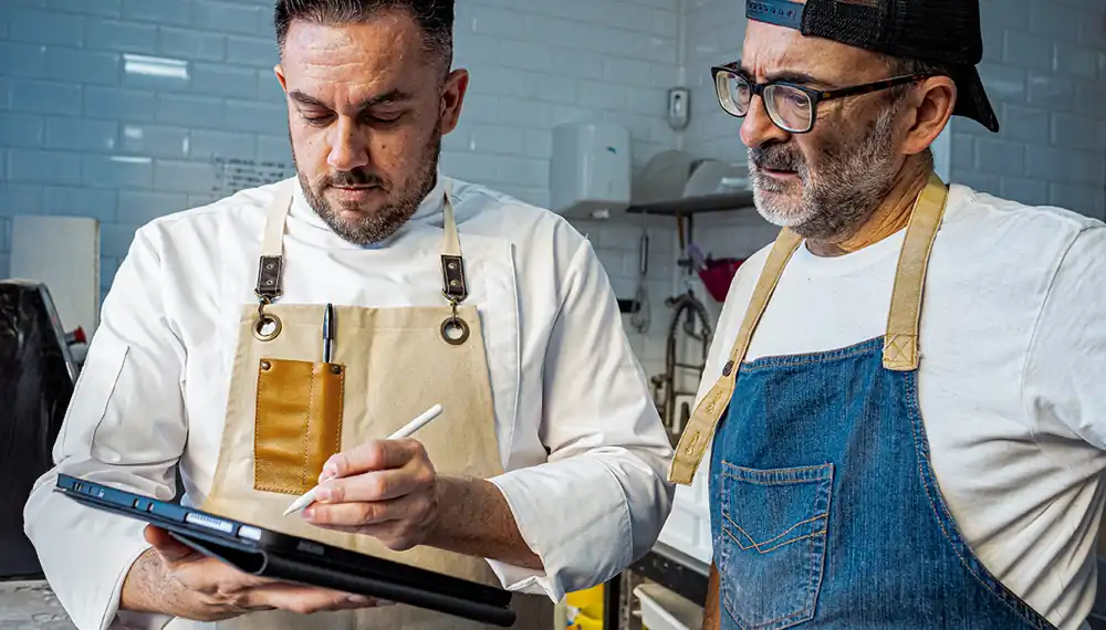 Workers using food and beverage software on a table