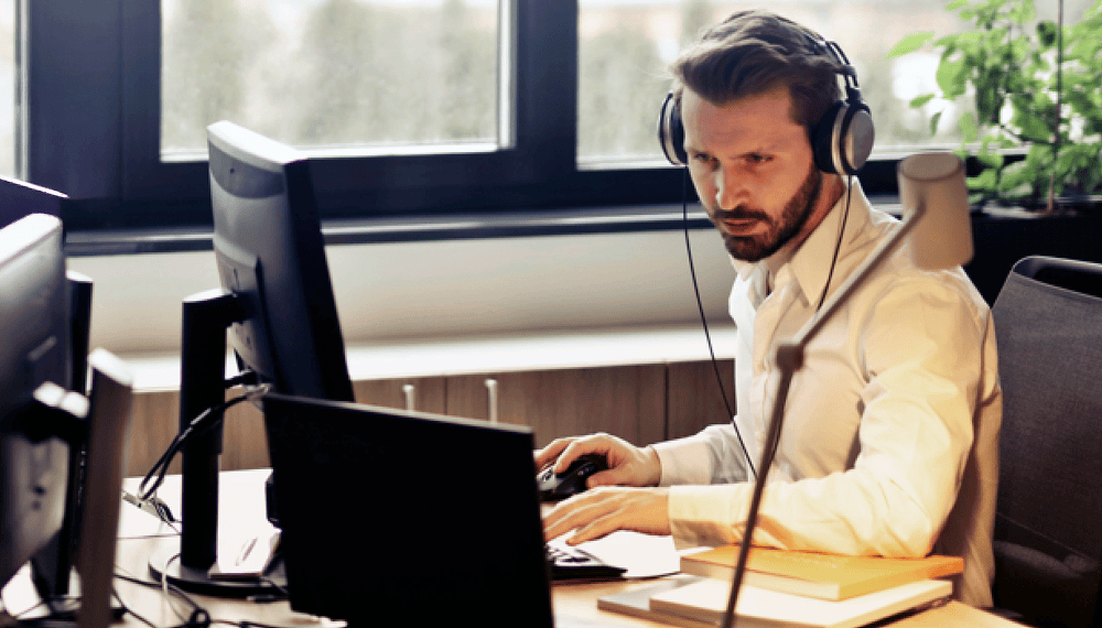 Person wearing headphones while using a laptop