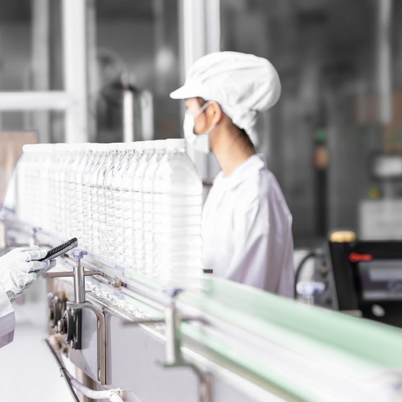 Asian females in inspecting water bottles on an automated conveyor belt