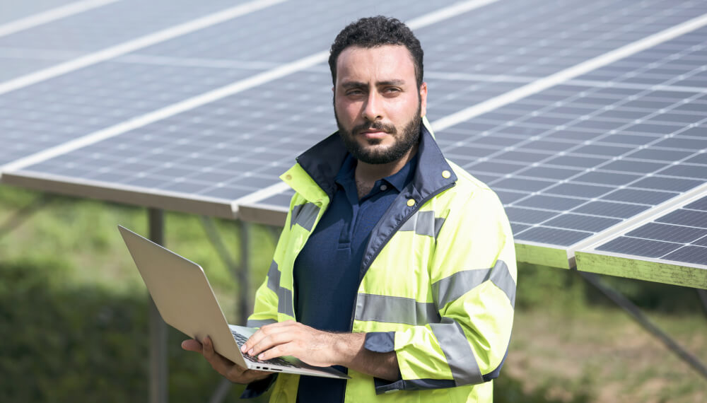 Worker using Infor MES standing in front of solar panels