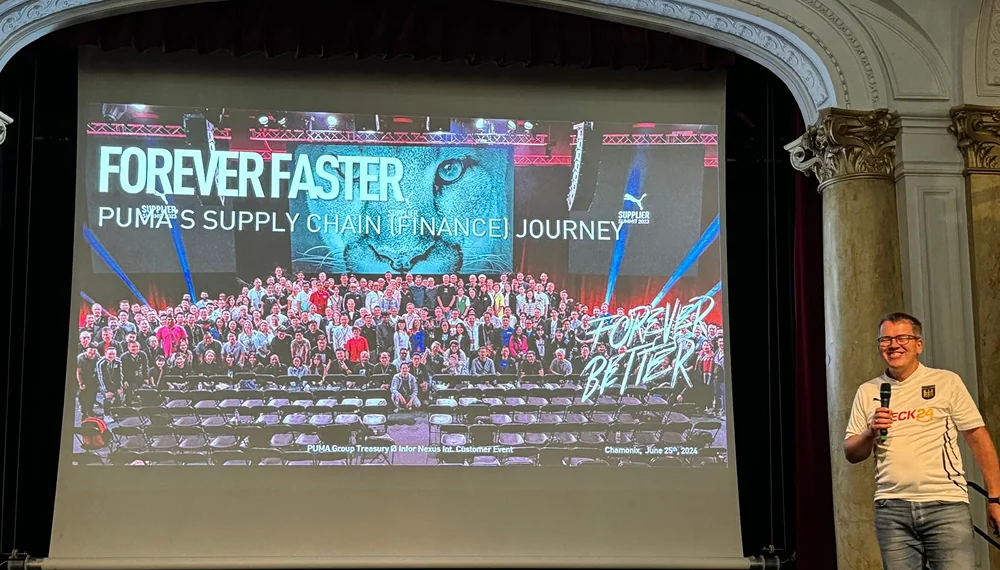 Frank Waechter, VP of Treasury at Puma, standing in front of a screen presenting Puma’s SCF journey