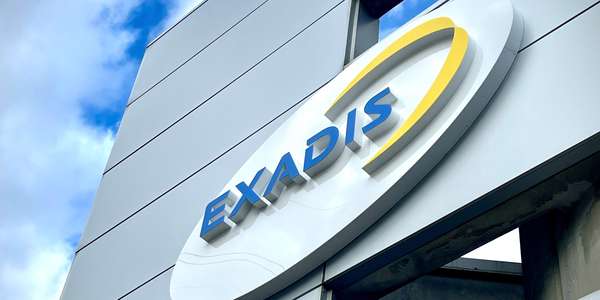 Exadis logo on  gray building facade with sky