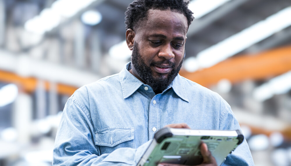 Businessman holding a tablet inside a manufacturing factory