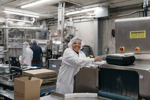 food factory worker smiling at the camera while working