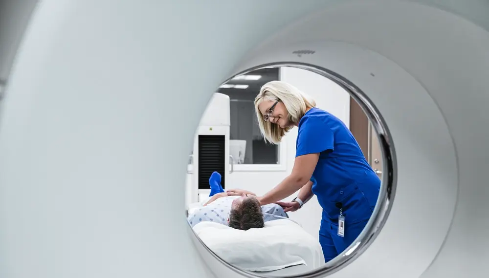 Nurse preparing a patient for an MRI scan