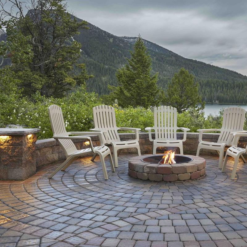 outdoor chairs around patio firepit with lake and mountains